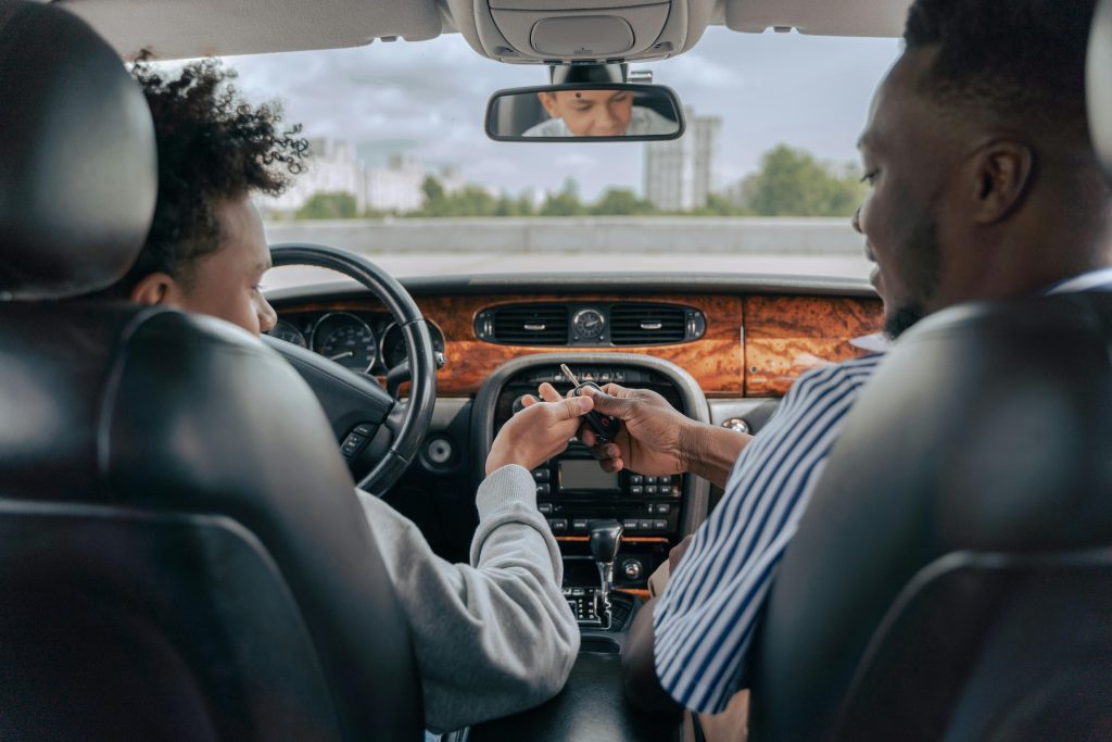 Driver handing car keys to passenger, symbolizing car ownership transfer in Nigeria